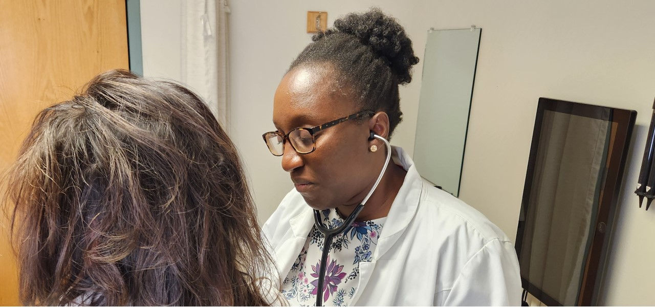 Dr. Mutsa Munjoma checks on a patient in an exam room